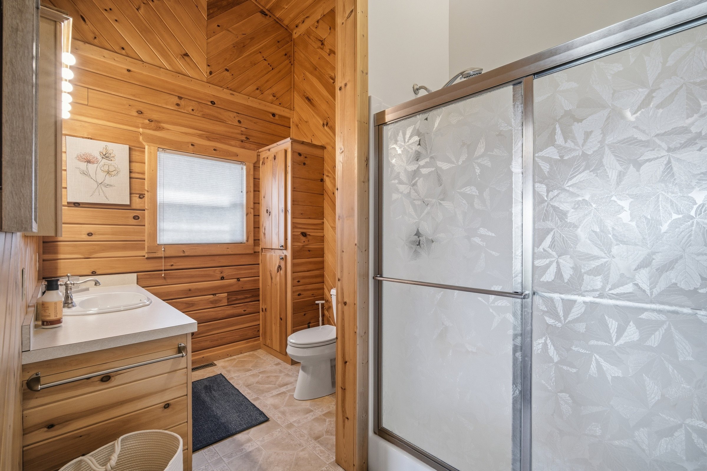 Bathroom with shower, vanity, and toilet